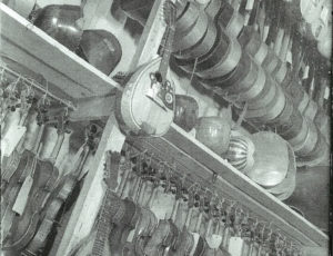 Confiscated musical instruments stored on shelving (source: http://collections.jewishmuseum.cz)