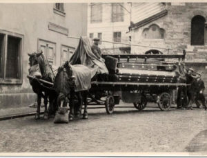 Povoz s nábytkem ze synagogy před Starým židovským hřbitovem, vpravo Obřadní síň, vlevo Klausová synagoga (zdroj: http://collections.jewishmuseum.cz)